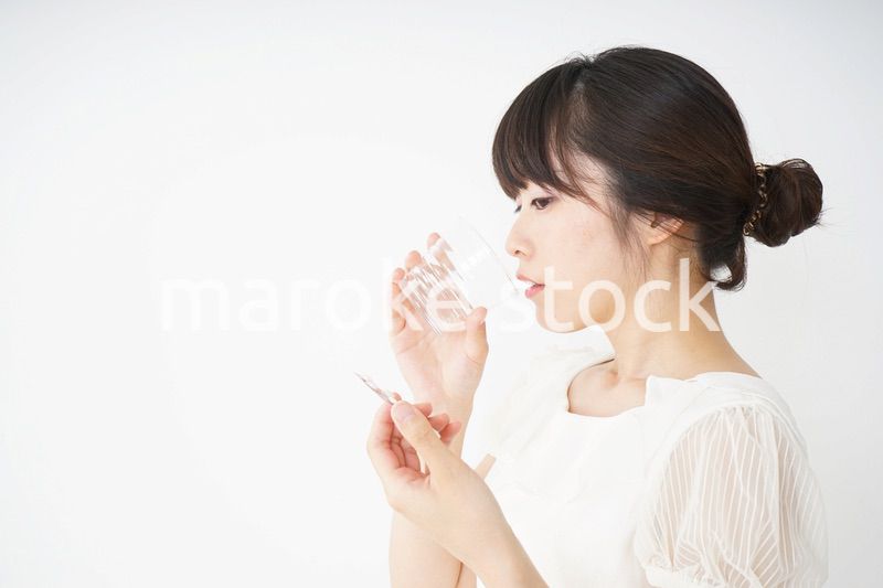 内服薬を服用する若い女性