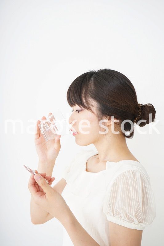 内服薬を服用する若い女性