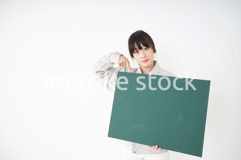 黒板を持つ作業服姿の女性