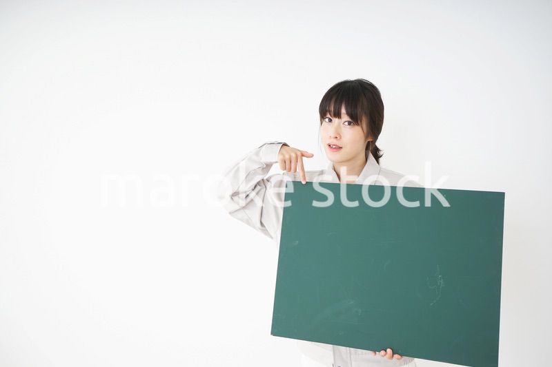 黒板を持つ作業服姿の女性