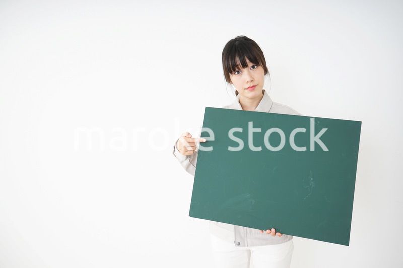 黒板を持つ作業服姿の女性