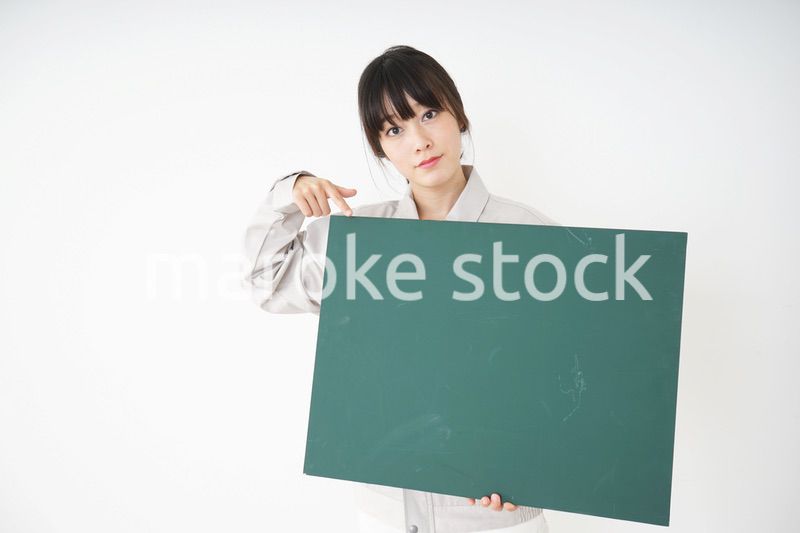 黒板を持つ作業服姿の女性