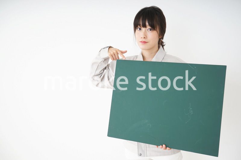 黒板を持つ作業服姿の女性