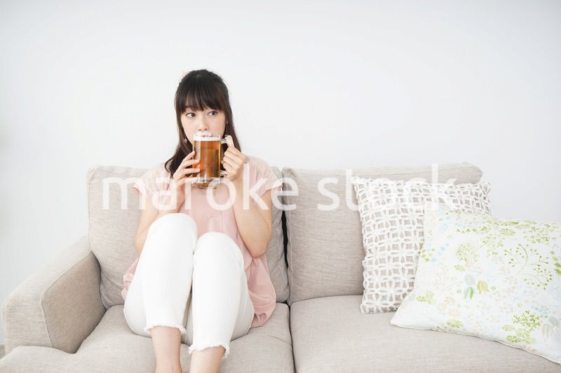 自宅でビールを飲む若い女性