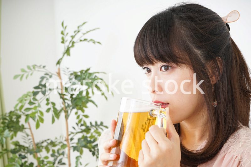 自宅でビールを飲む若い女性