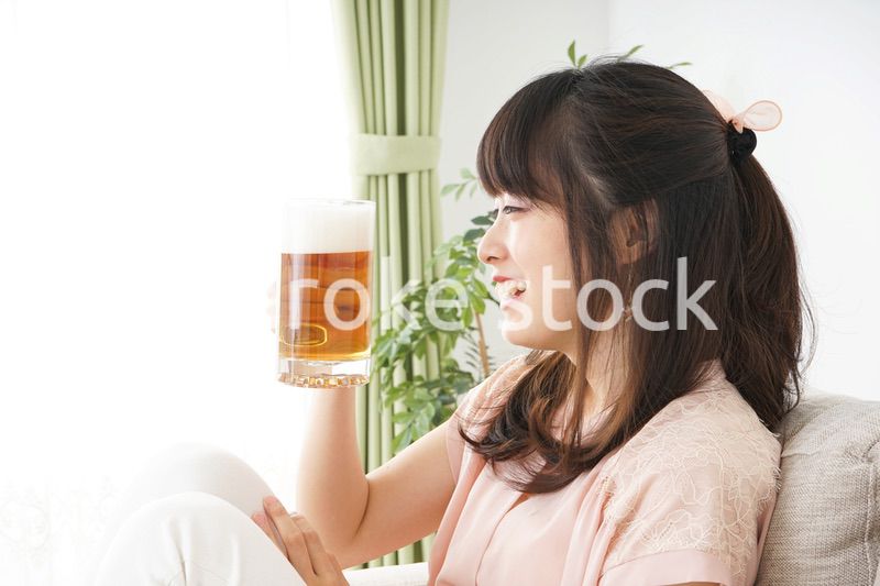 自宅でビールを飲む若い女性