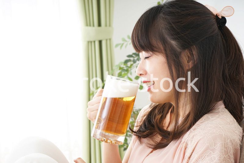 自宅でビールを飲む若い女性