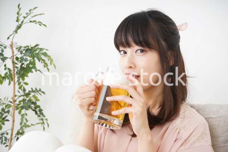 自宅でビールを飲む若い女性