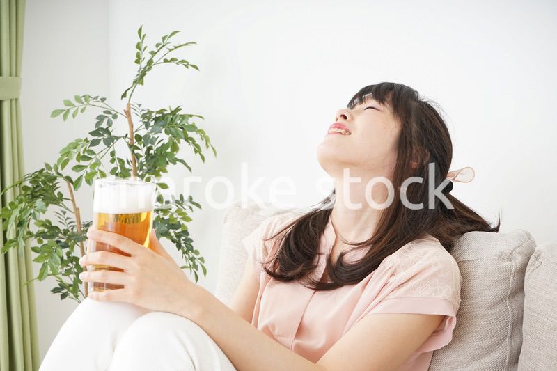 自宅でビールを飲む若い女性
