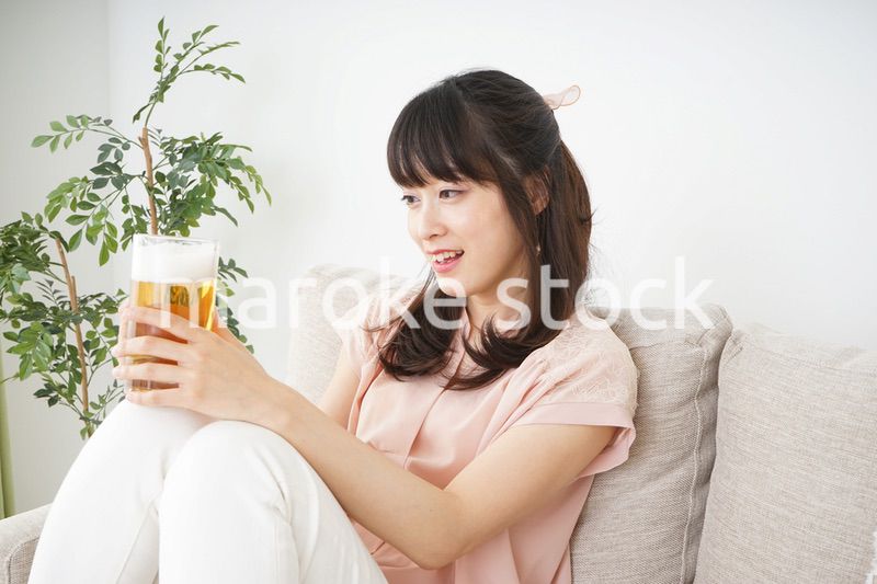 自宅でビールを飲む若い女性