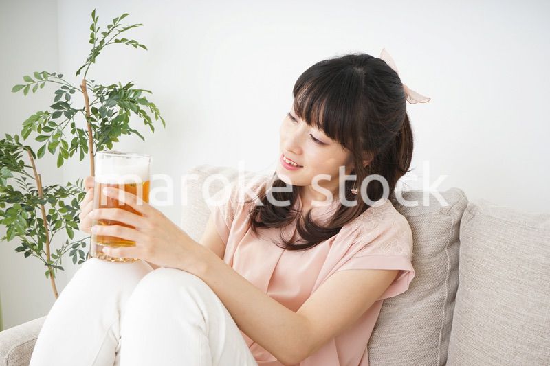 自宅でビールを飲む若い女性