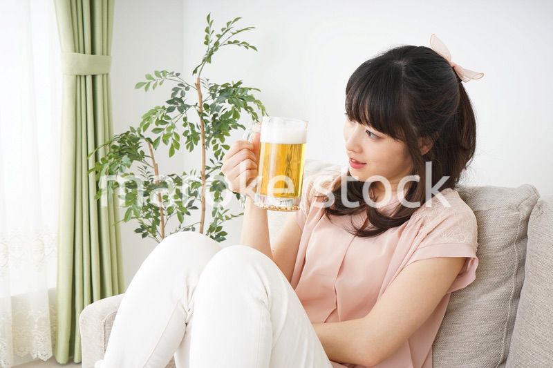 自宅でビールを飲む若い女性
