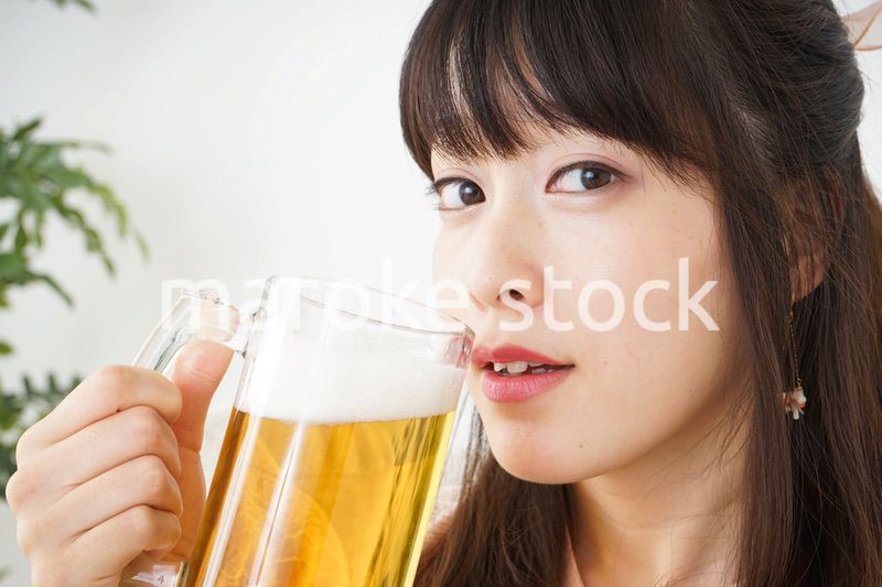 自宅でビールを飲む若い女性