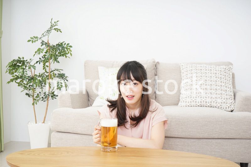 自宅でビールを飲む若い女性
