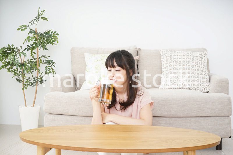 自宅でビールを飲む若い女性