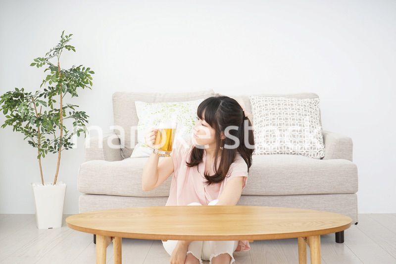 自宅でビールを飲む若い女性
