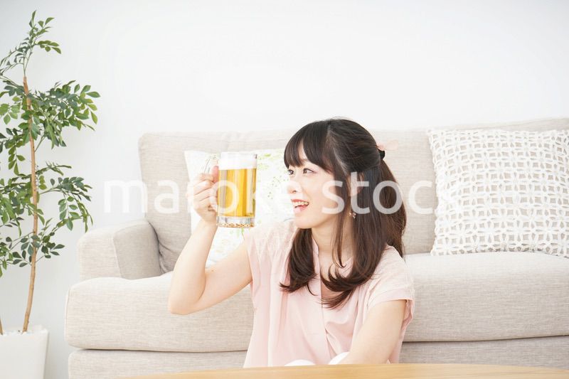 自宅でビールを飲む若い女性