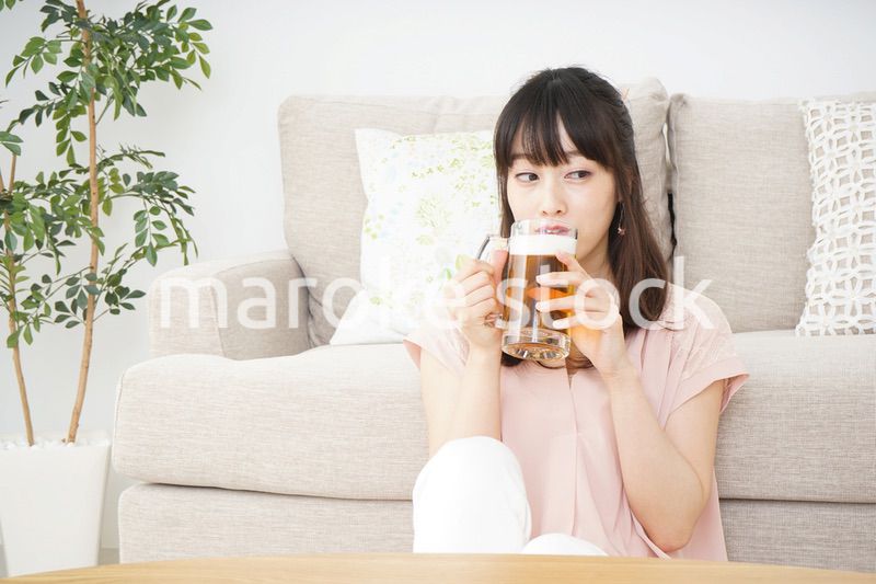 自宅でビールを飲む若い女性