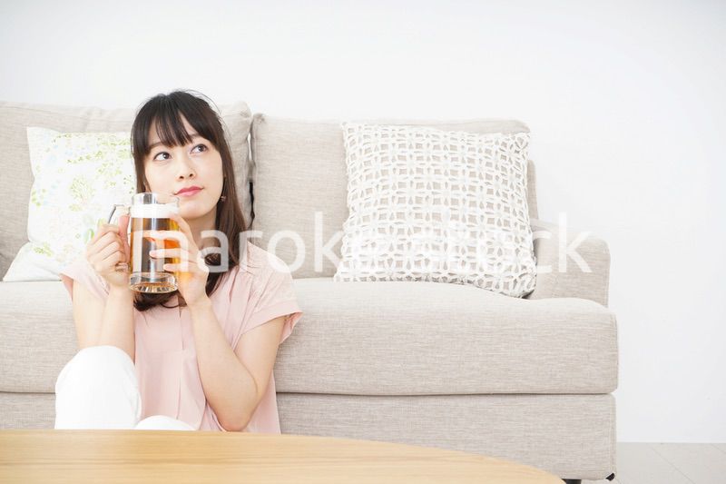 自宅でビールを飲む若い女性