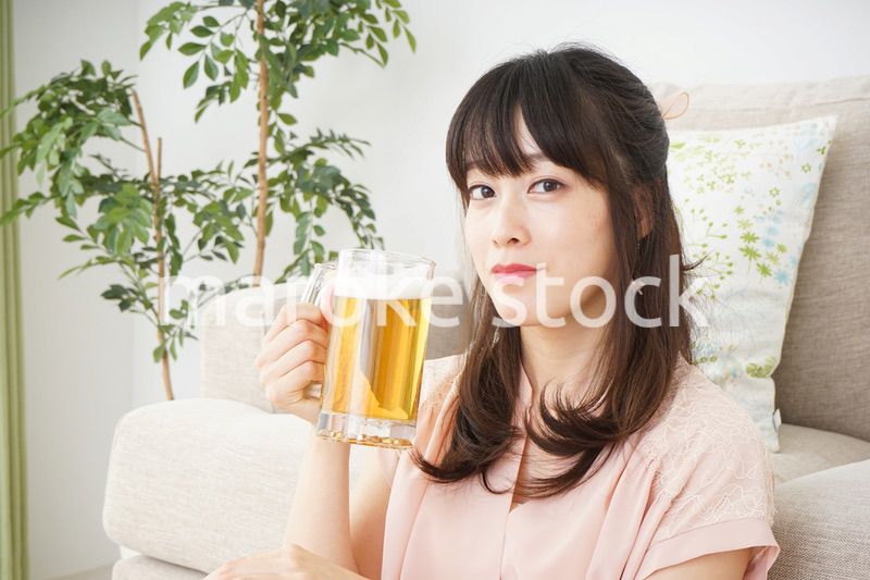 自宅でビールを飲む若い女性