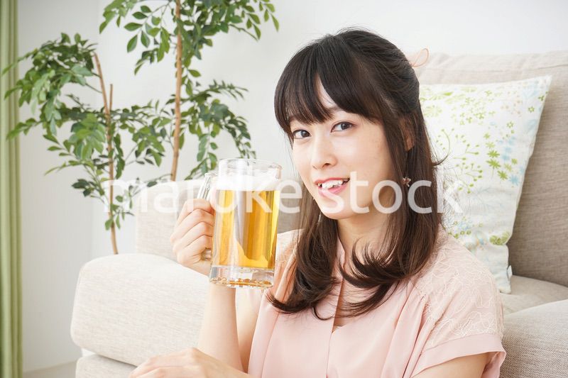 自宅でビールを飲む若い女性