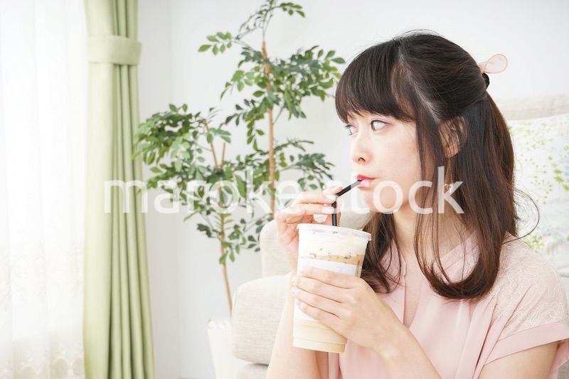 部屋でコーヒーを飲む若い女性