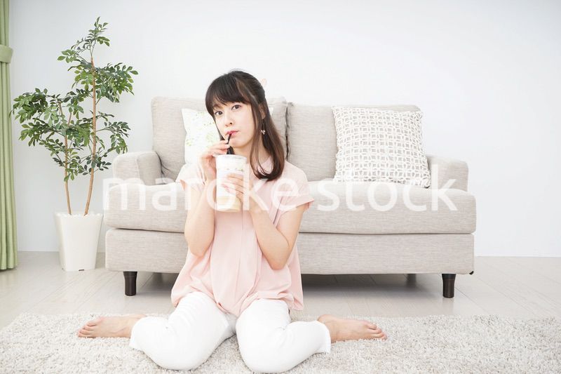 部屋でコーヒーを飲む若い女性