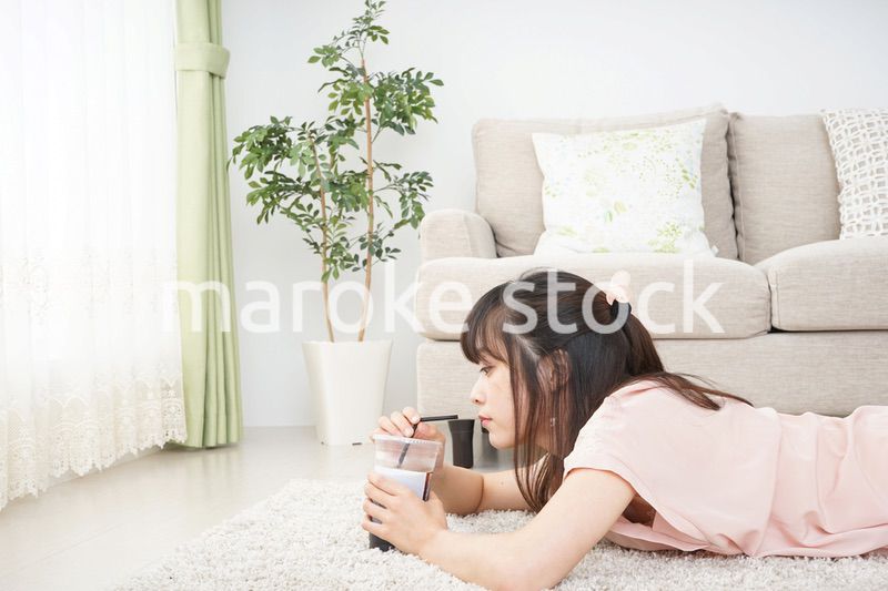 部屋でコーヒーを飲む若い女性