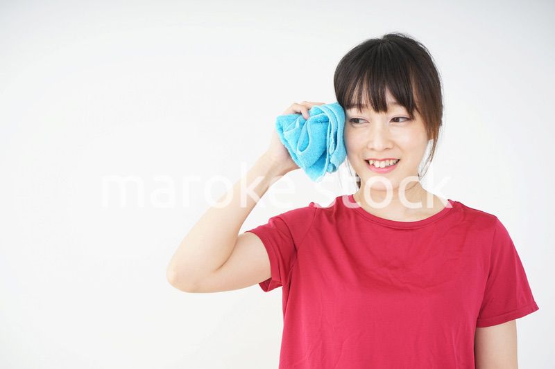 スポーツ中に汗を拭く若い女性