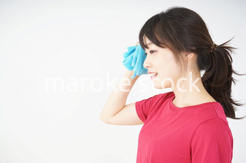 スポーツ中に汗を拭く若い女性