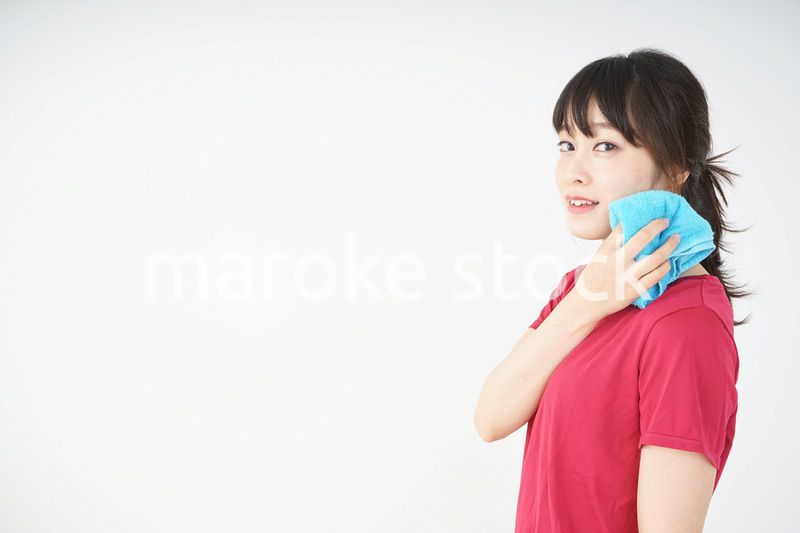 スポーツ中に汗を拭く若い女性