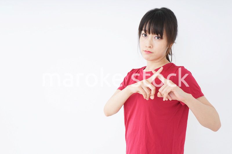 バツサインをするスポーツインストラクター