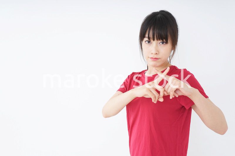 バツサインをするスポーツインストラクター