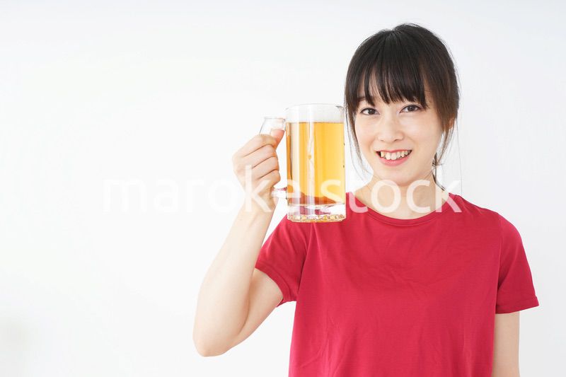 運動後にビールを飲む若い女性
