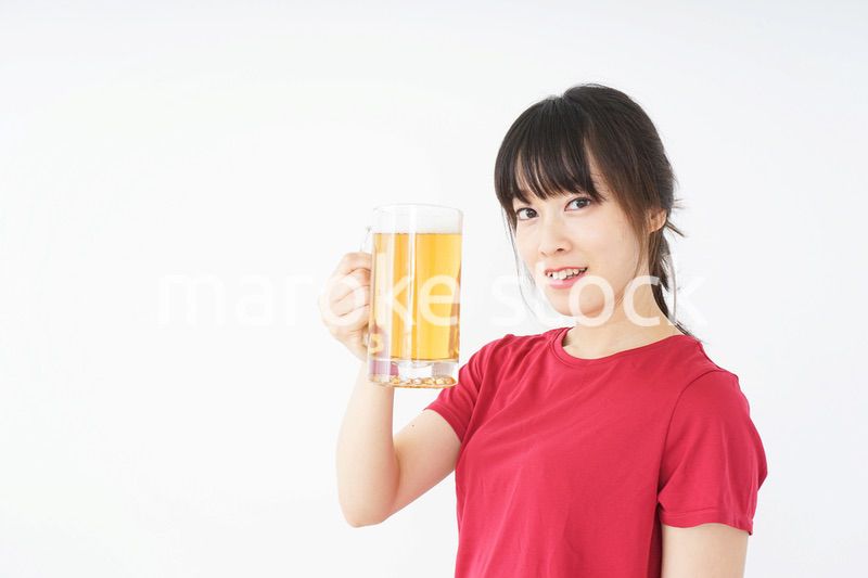 運動後にビールを飲む若い女性