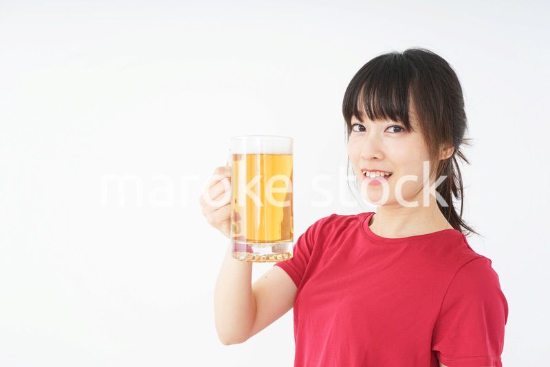 運動後にビールを飲む若い女性