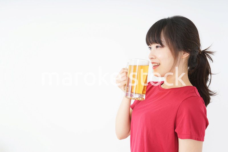 運動後にビールを飲む若い女性