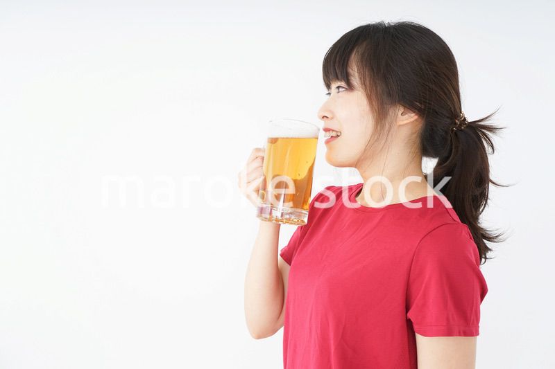 運動後にビールを飲む若い女性
