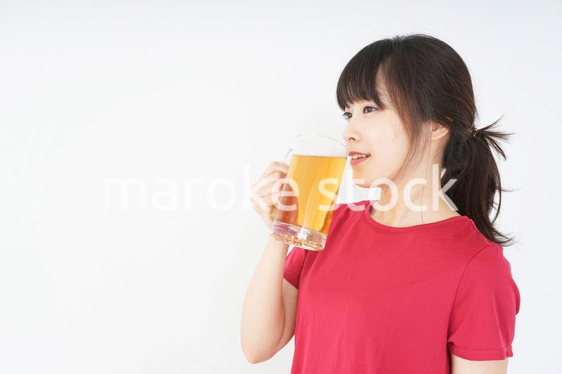 運動後にビールを飲む若い女性