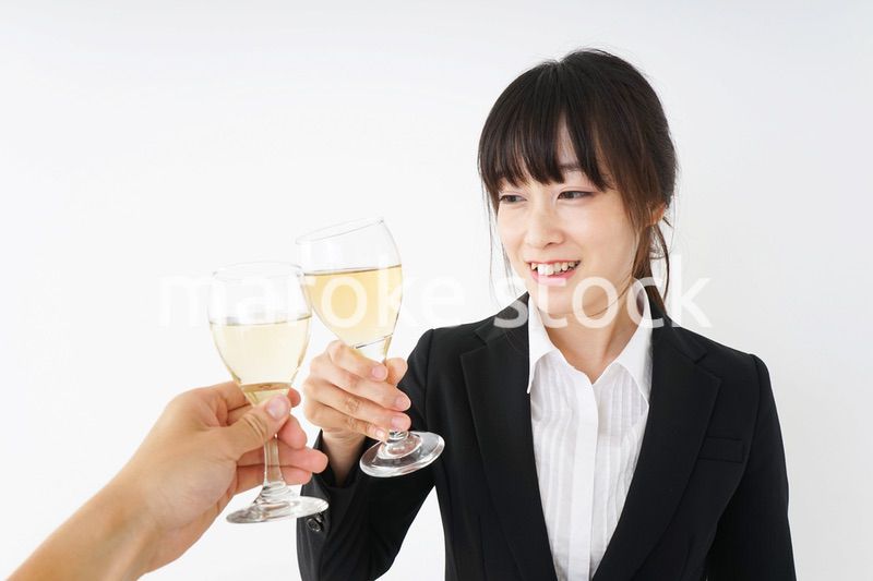 スーツ姿でお酒を飲む若い女性