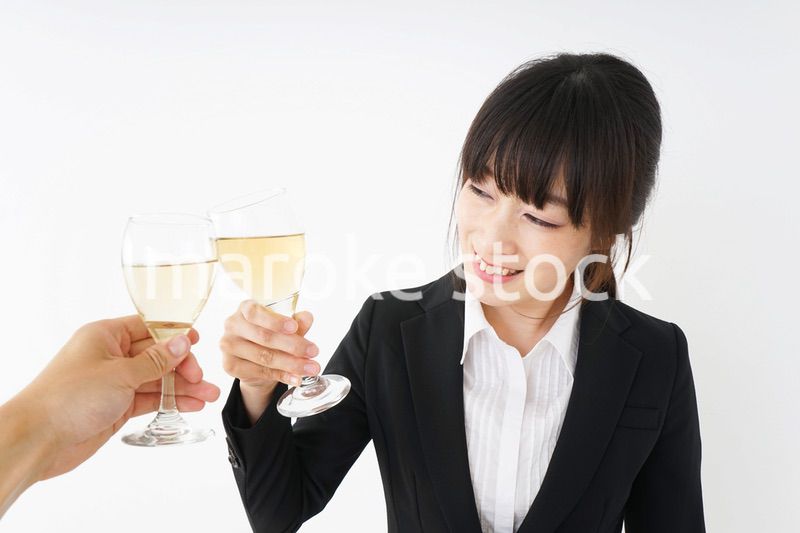 スーツ姿でお酒を飲む若い女性