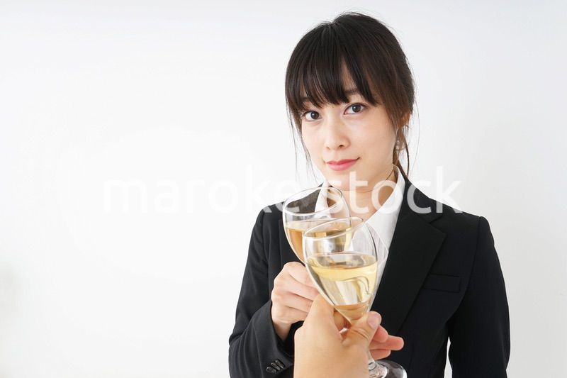 スーツ姿でお酒を飲む若い女性