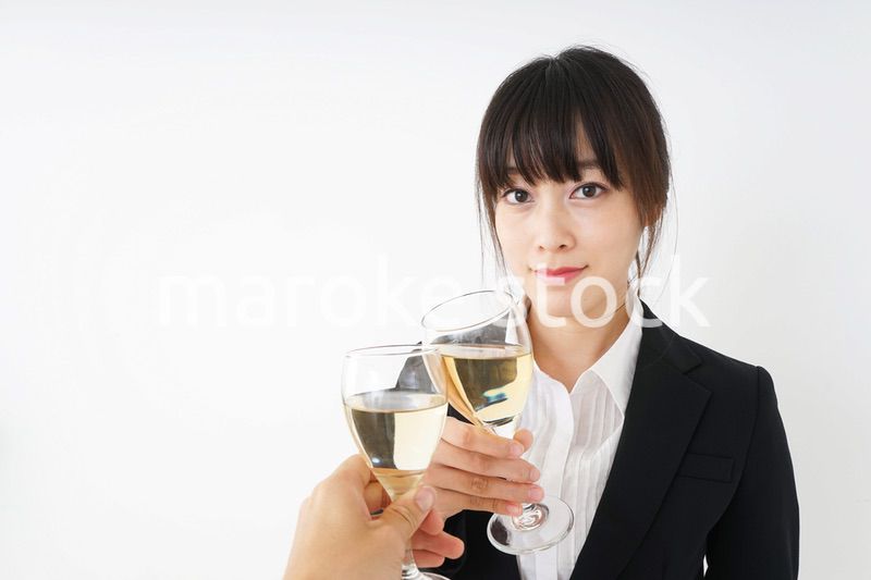 スーツ姿でお酒を飲む若い女性