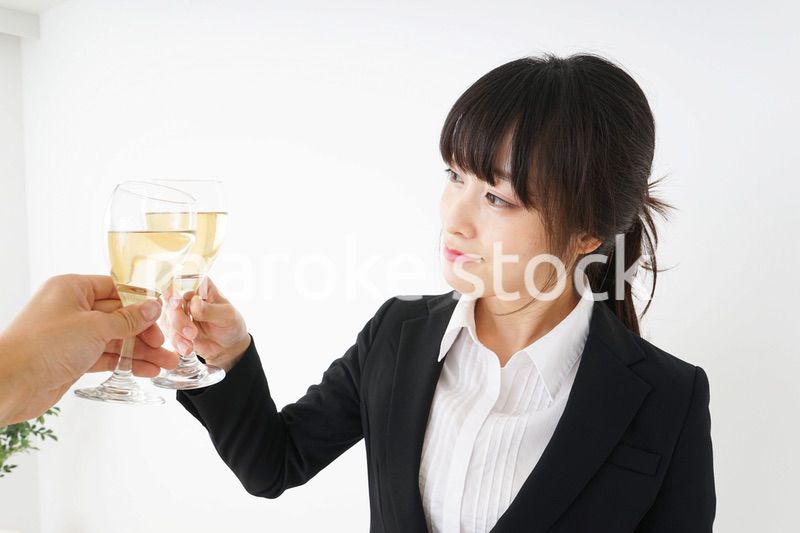 スーツ姿でお酒を飲む若い女性