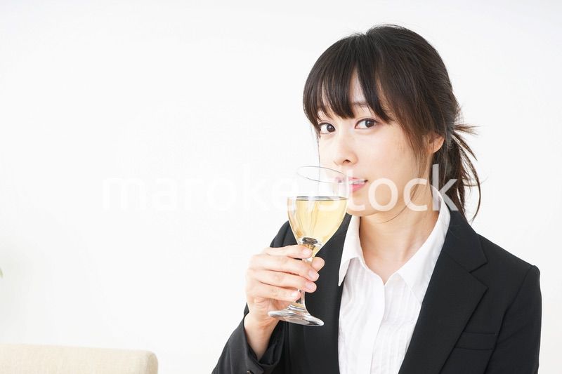 スーツ姿でお酒を飲む若い女性