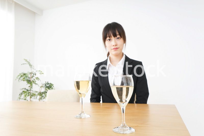 スーツ姿でお酒を飲む若い女性