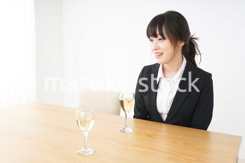 スーツ姿でお酒を飲む若い女性