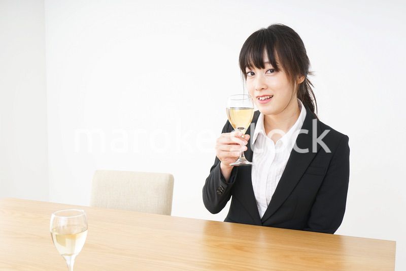スーツ姿でお酒を飲む若い女性