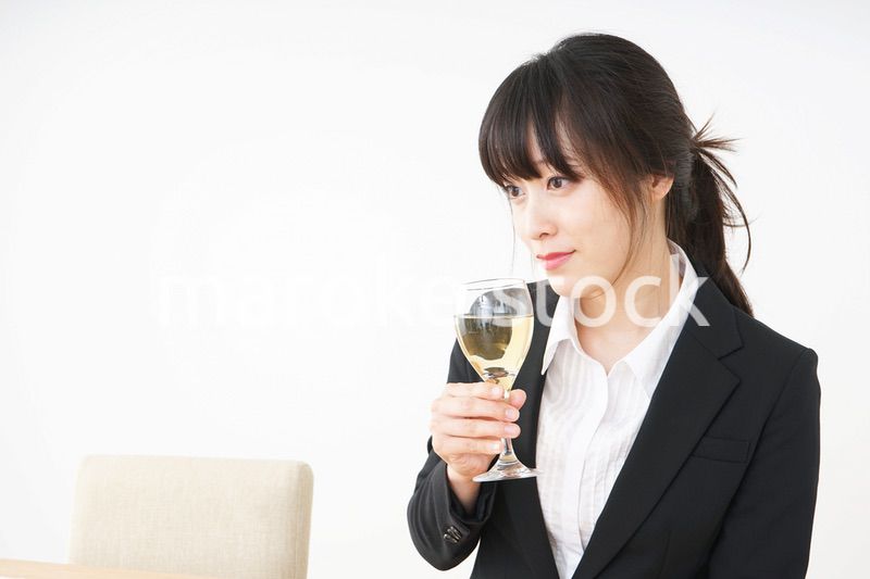 スーツ姿でお酒を飲む若い女性