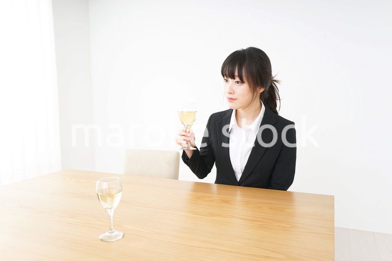 スーツ姿でお酒を飲む若い女性